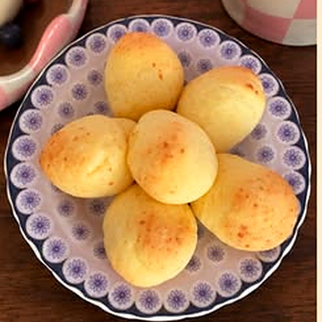 Pães de queijo em prato de louça pintada com flores